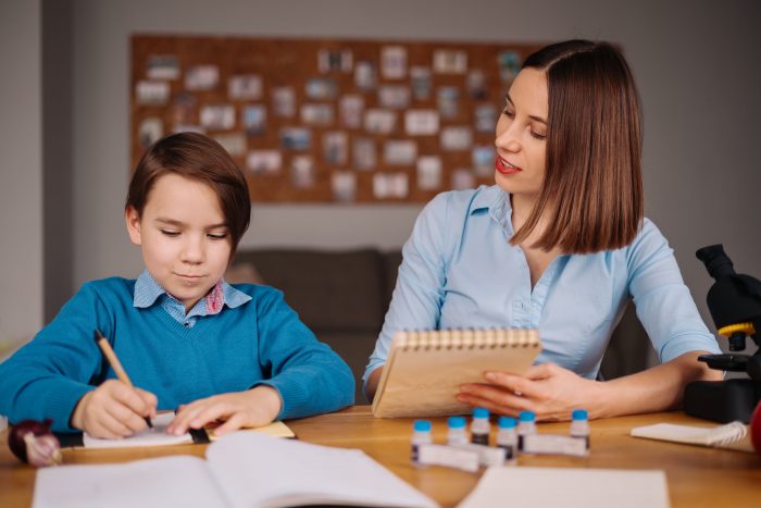 A boy studying with his female teacher